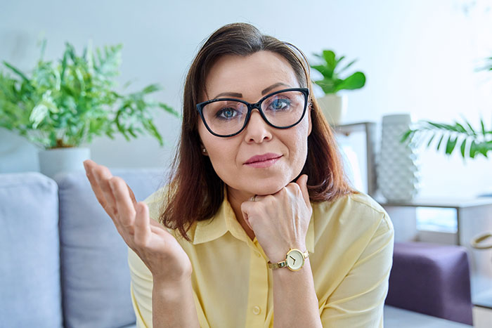 Woman in glasses and yellow shirt expressing frustration, illustrating a guy refusing to be step-father to fianc&eacute;e&rsquo;s children.