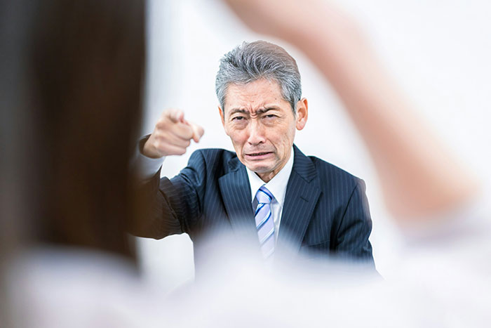 Angry boss pointing and reprimanding employee who didn&rsquo;t check their email while taking public transit to work.