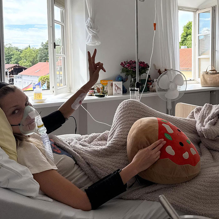 Patient resting in hospital bed with oxygen mask and blankets, fans stunned by Bella Hadid Victoria&rsquo;s Secret angel wings weight reveal