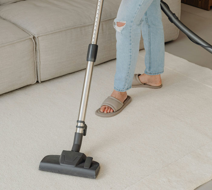 Person vacuuming a carpet indoors, illustrating hilarious instances of people being shockingly unaware of common knowledge.