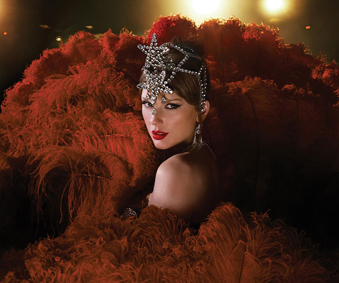 Taylor Swift in glamorous red outfit with jeweled headpiece, hinting a secret jab at her ex in new music video.