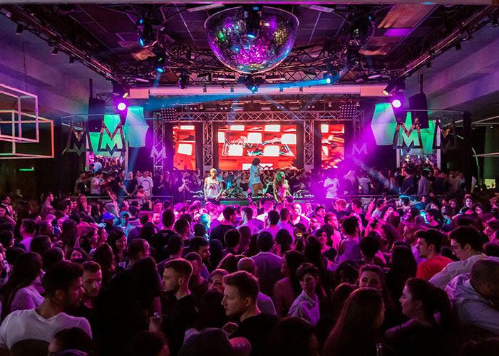 Crowded nightclub with colorful lighting and people dancing, showcasing energetic life hacks discovered accidentally.