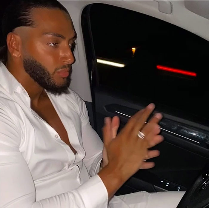 Man in white shirt inside car at night, related to influencer's fake syringe attack pranks and arrest controversy.