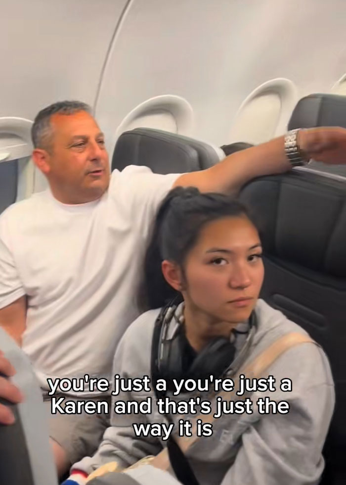 Passenger and woman in heated exchange on plane, illustrating internet divided over Karen confrontation with multiple passengers. Passenger and woman in heated exchange on plane, illustrating internet divided over Karen confrontation with multiple passengers.