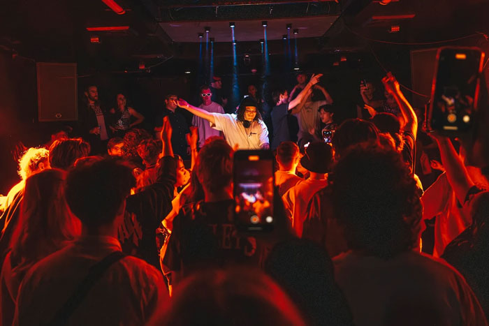 Crowded men-only gay bar with vibrant lighting, capturing the energy amid controversy over accusations of blatant misogyny.