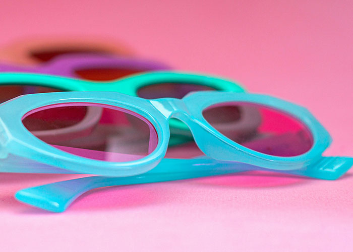 Close-up of colorful sunglasses on pink surface, illustrating creative loopholes used against horrible bosses.