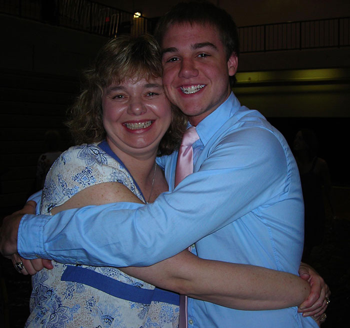 Mom of late Taylor Swift friend smiling and hugging young man in a gymnasium setting after 15 years of loss.