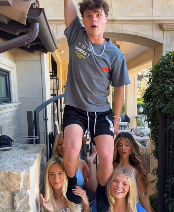 Young man lifted by a group of women outside a stone house, related to disturbing new details after adult star split.
