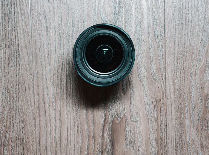 Camera lens on a wooden surface representing crime evidence in stories about worst crimes in hometowns shared by people.
