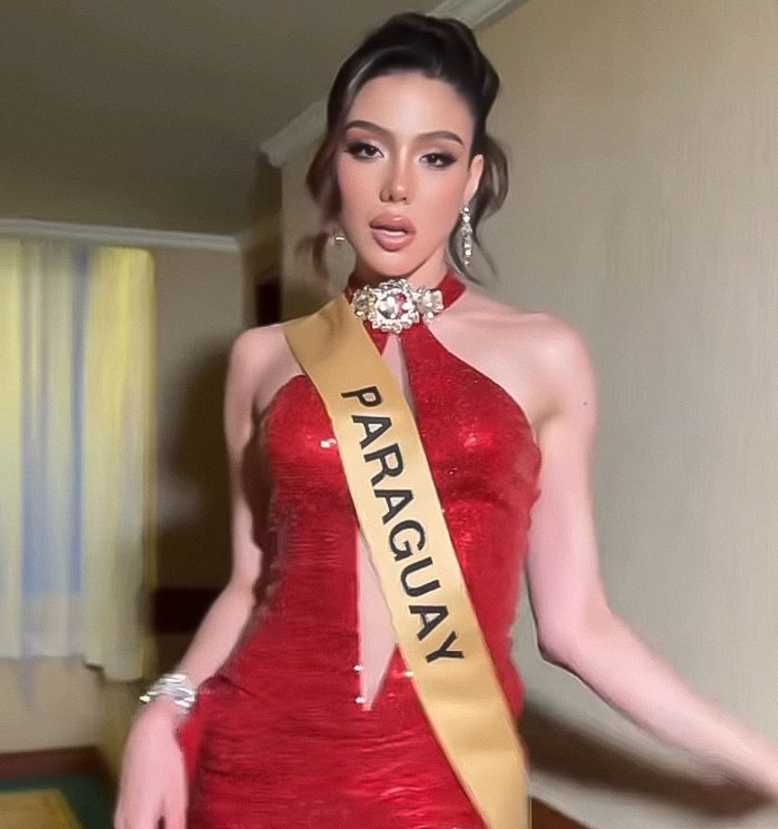 Miss Panama in a red dress wearing a sash posing indoors, related to painfully awkward onstage fail moments.