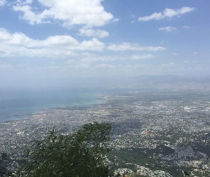 Aerial view of a sprawling coastal city under a partly cloudy sky, one of the places people wouldn’t revisit.