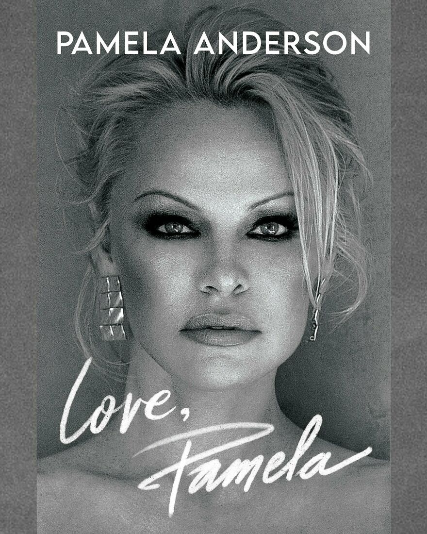 Black and white close-up portrait of Pamela Anderson with bold makeup and signature earrings highlighting her net worth status.