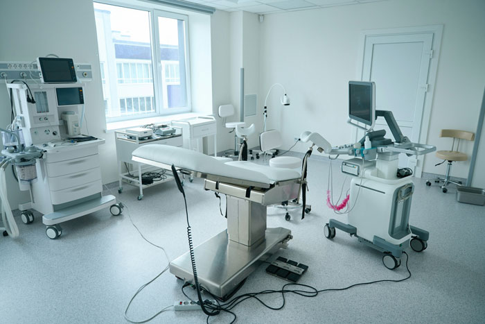 Medical examination room with equipment and an empty examination table related to doctor autopsy investigation scenario