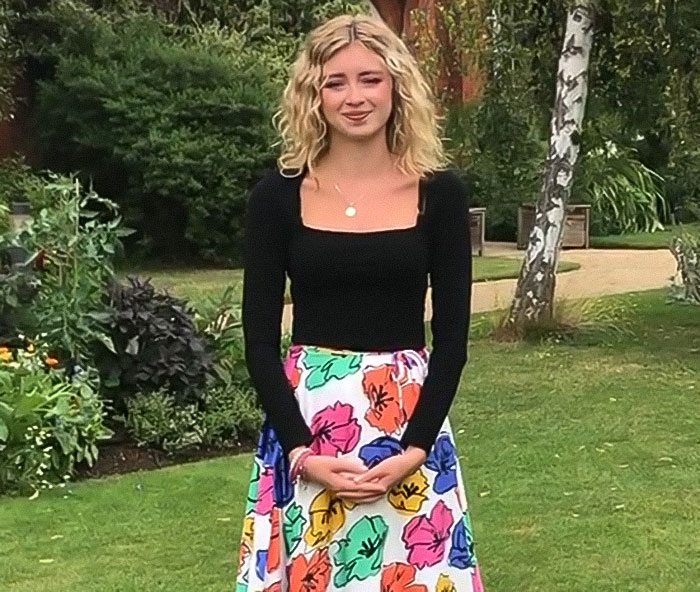 Young woman in floral skirt standing outdoors, representing coroner exposing mom for influencing refusal of chemo treatment. Young woman in floral skirt standing outdoors, representing coroner exposing mom for influencing refusal of chemo treatment.