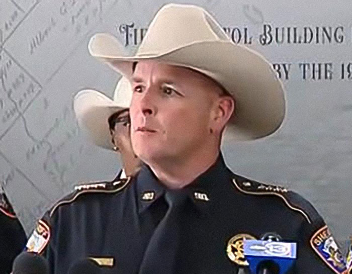 Sheriff in uniform and cowboy hat addressing serious case of 12-year-old escaping severe mistreatment at home.