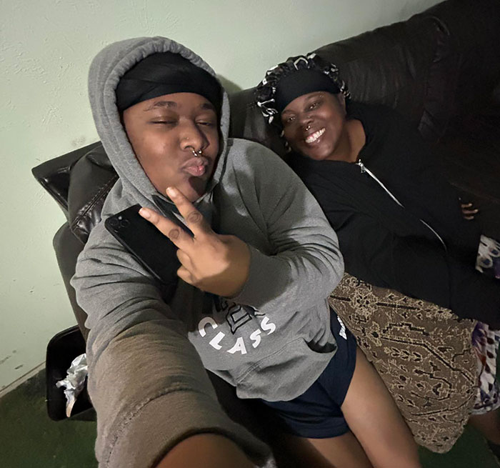 Two women sitting on a couch smiling, related to woman loses life outside pet store after argument keywords.