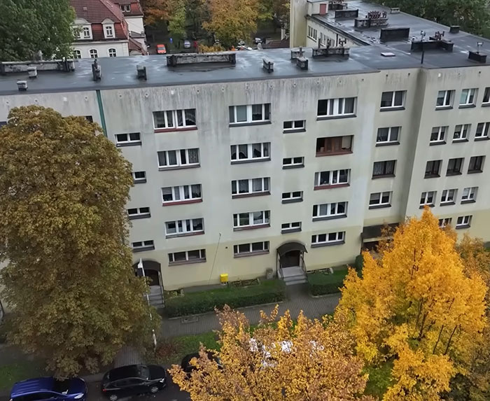 A residential apartment building in autumn with trees outside, related to woman missing for 27 years found emaciated.