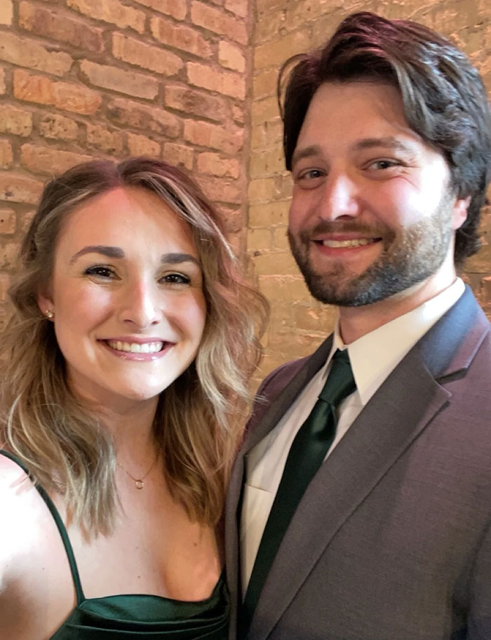 Couple dressed formally smiling in front of brick wall, officials reveal cause of passing days before wedding anniversary.