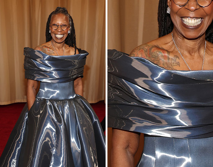 Smiling woman in metallic silver dress showing her shoulder tattoo at a formal event, celebrating celebrities with tattoos.