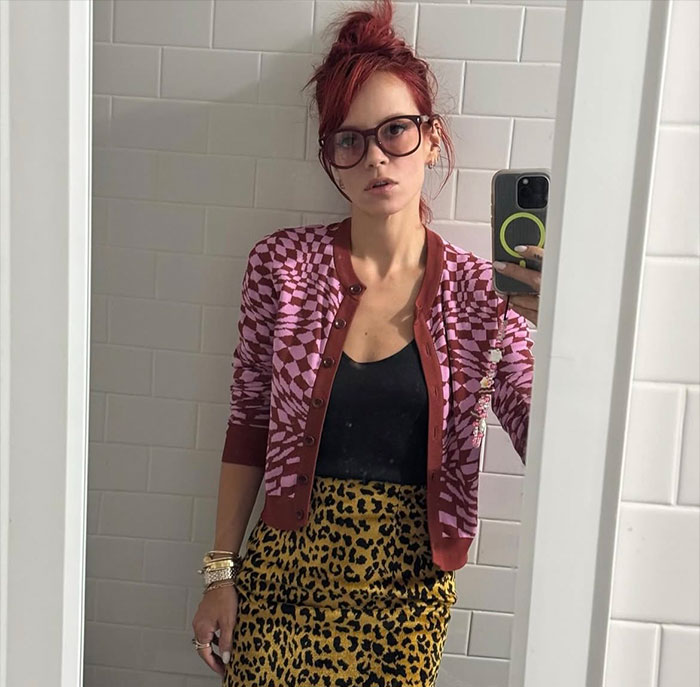Lily Allen taking a mirror selfie in a patterned cardigan and leopard print skirt promoting new album and controversy.
