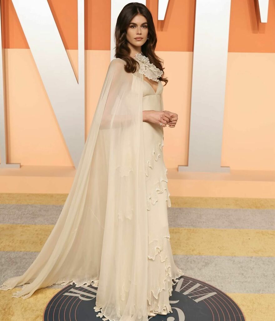 Kaia Gerber dressed in an elegant cream gown with cape, representing nepo babies shaping Hollywood’s new generation.