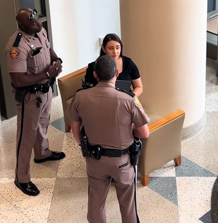 Two Florida police officers talking to a woman in a public building about a dad-to-be waking up from coma incident. Two Florida police officers talking to a woman in a public building about a dad-to-be waking up from coma incident.