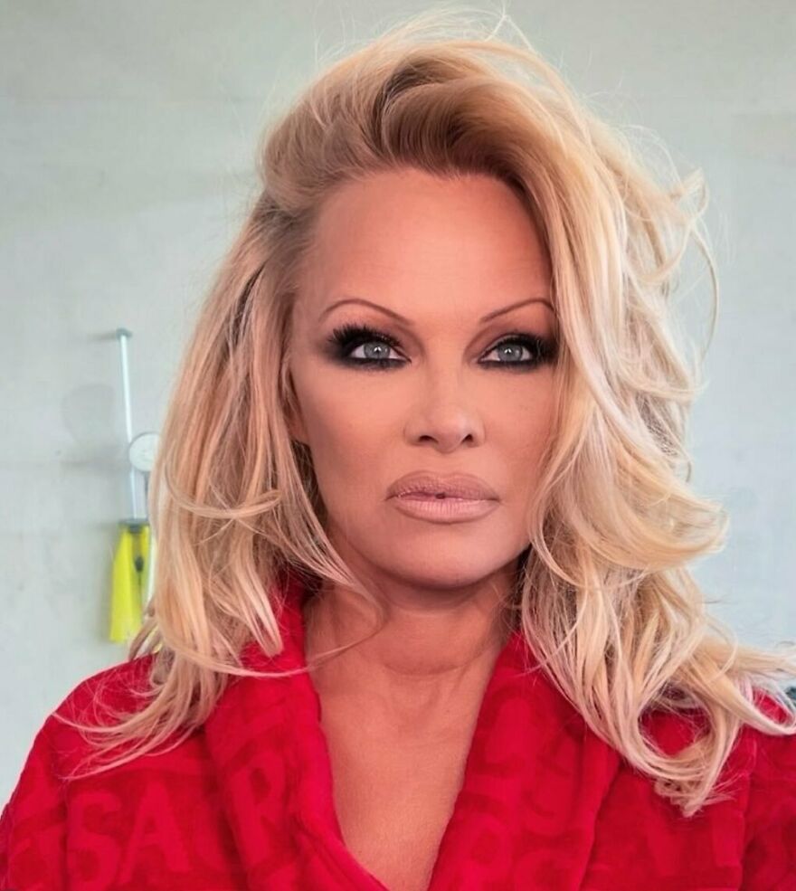 Pamela Anderson with styled blonde hair and makeup, showcasing her net worth and decades of reinvention.
