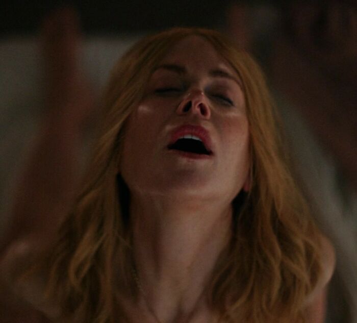Nicole Kidman with eyes closed and head tilted back, portraying intimacy in a dimly lit setting.