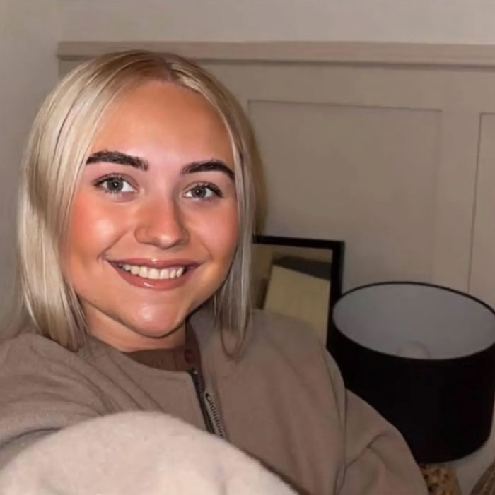 Woman smiling indoors with blonde hair, linked to story about her outrageous 10-month lie involving a doll baby.