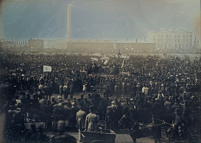 Large crowd gathered outdoors in an early photo that survived from the time when photography was new.