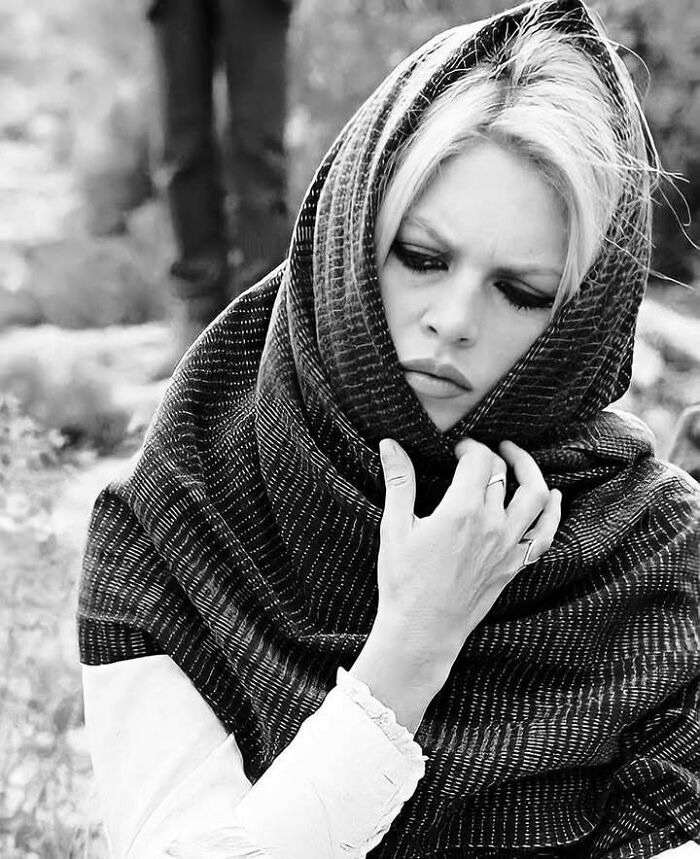 Black and white portrait of a woman wrapped in a shawl, reflecting a timeless mark in the movie and music industries.