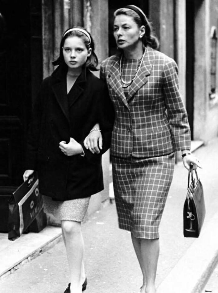 Black and white photo of two women walking arm in arm, representing people who left a mark in the movie industries.