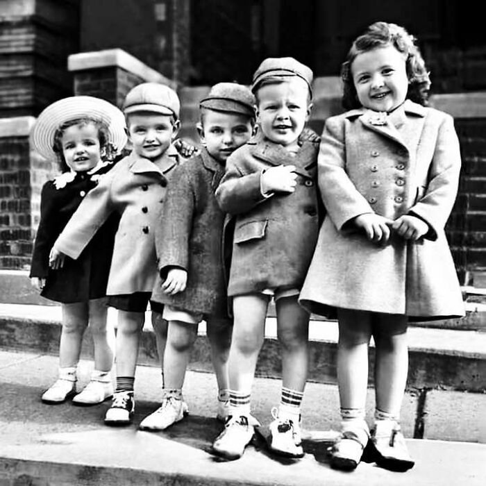 Group of children standing on steps in vintage attire, symbolizing early stories from the movie and music industries.