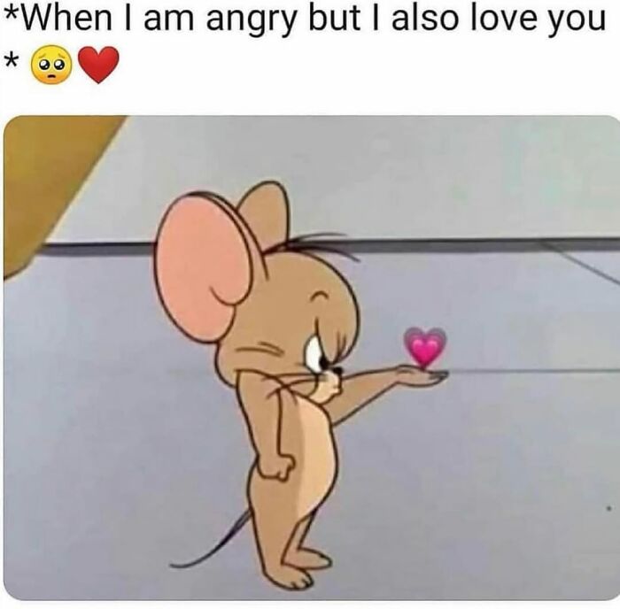 Cartoon mouse holding a small heart emoji, illustrating a relatable meme about love and anger in relationships.