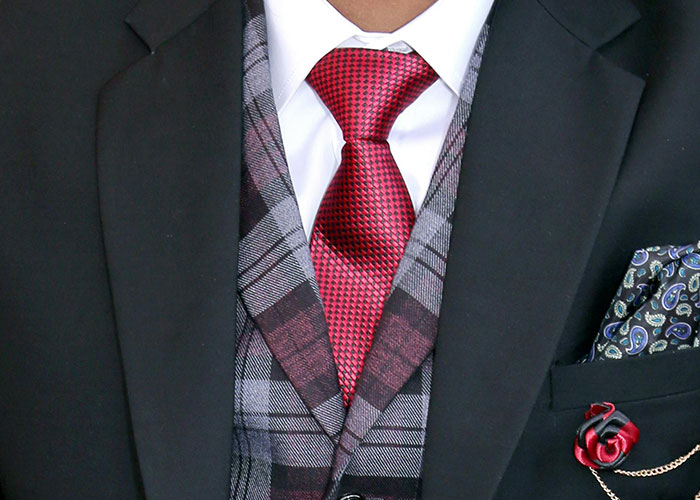 Man wearing a black suit with plaid vest and red tie, symbolizing clever loopholes used against horrible bosses.