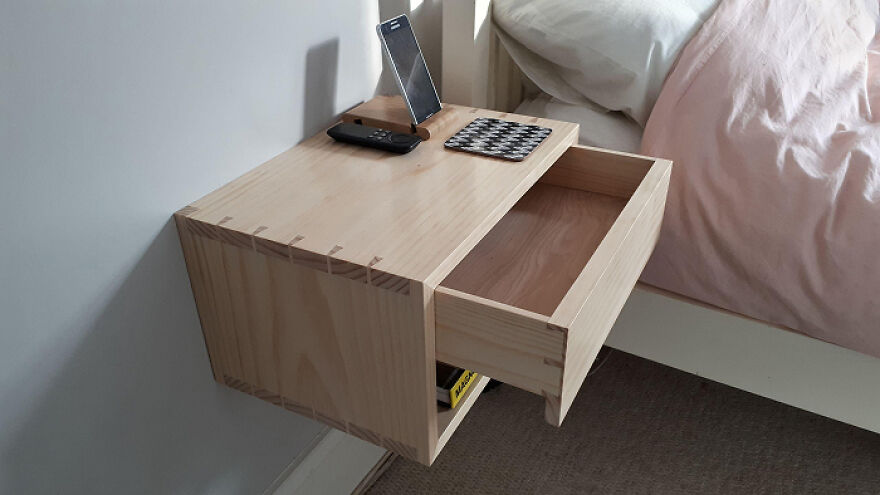 Floating wooden bedside table with open drawer showing organization hacks for home storage solutions and decluttering.