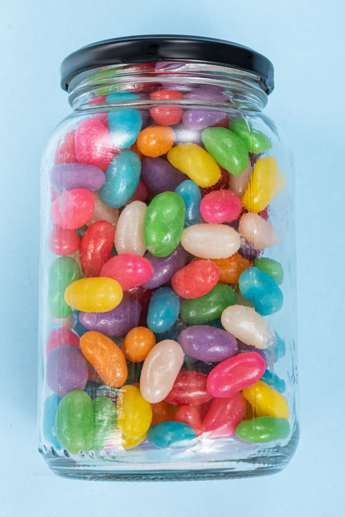 Jar filled with colorful jelly beans representing unexpected and awkward moments people saw at work.