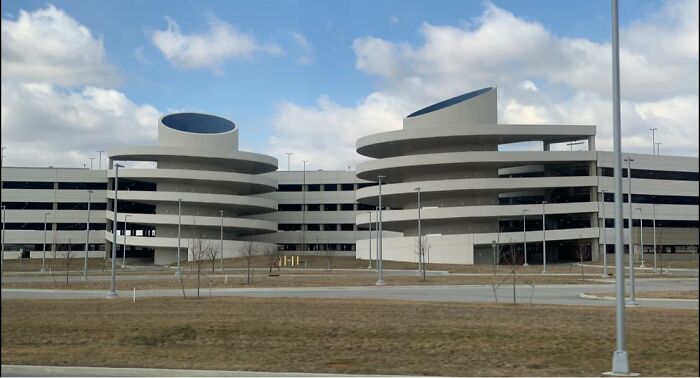 Modern empty parking garage with curved ramps, evoking beautiful yet unnerving liminal spaces in an urban setting.