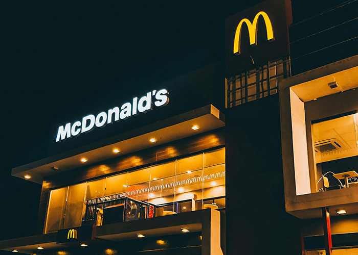 McDonald's restaurant at night with illuminated signs, illustrating stories of loopholes used against horrible bosses.
