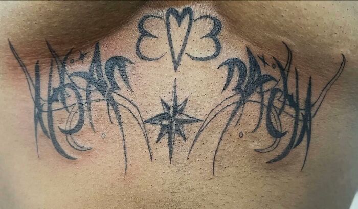 Black abstract tattoo with heart, star, and clover elements inked on upper chest, showcasing unique body tattoo designs.