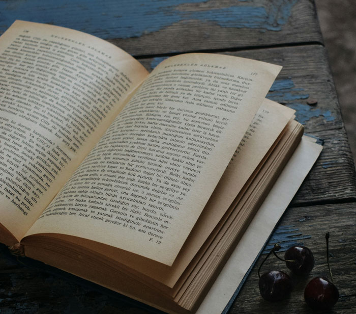 Open old book with yellowed pages on rustic wooden table, symbolizing stories of worst crimes in hometowns.