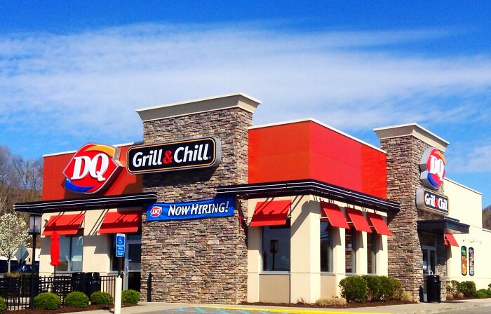 Dairy Queen Grill and Chill building with Now Hiring banner under bright blue sky, highlighting social cues misreading moments.
