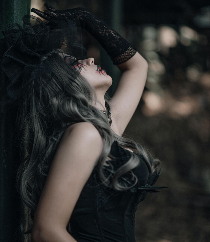 Woman in dark gothic attire and makeup posing dramatically in a moody setting, illustrating shocking common knowledge unawareness.