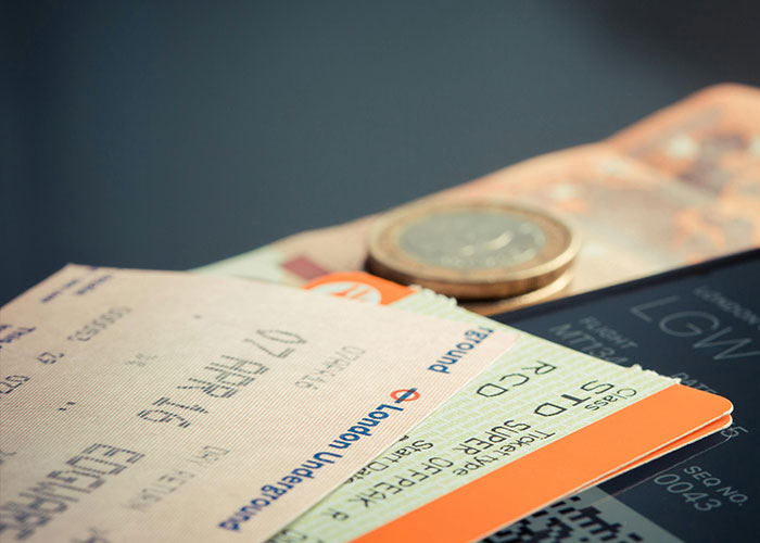Close-up of travel tickets and coins on a flat surface, illustrating moments linked to creepy things women said or did to men.