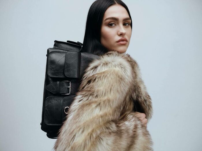 Young woman wearing a fur coat and black leather backpack representing nepo babies in Hollywood’s new generation.
