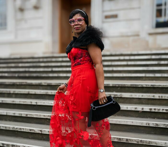 Woman in a red floral dress and fur stole attending a wedding, illustrating wedding guests who made the bride and groom regret.