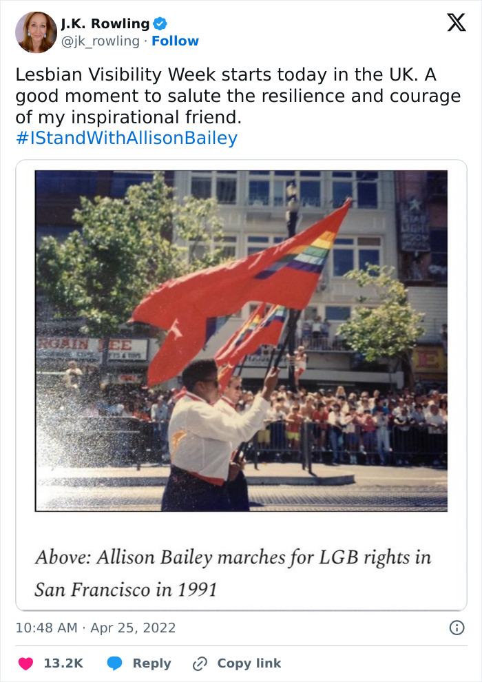 Alt text: Person carrying rainbow flags during LGB rights march in San Francisco, related to J.K. Rowling and lesbian visibility discussion.