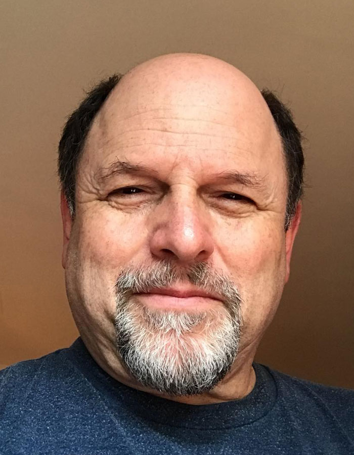 Close-up of a famous man with a salt-and-pepper goatee and short hair, highlighting height surprises of famous men.