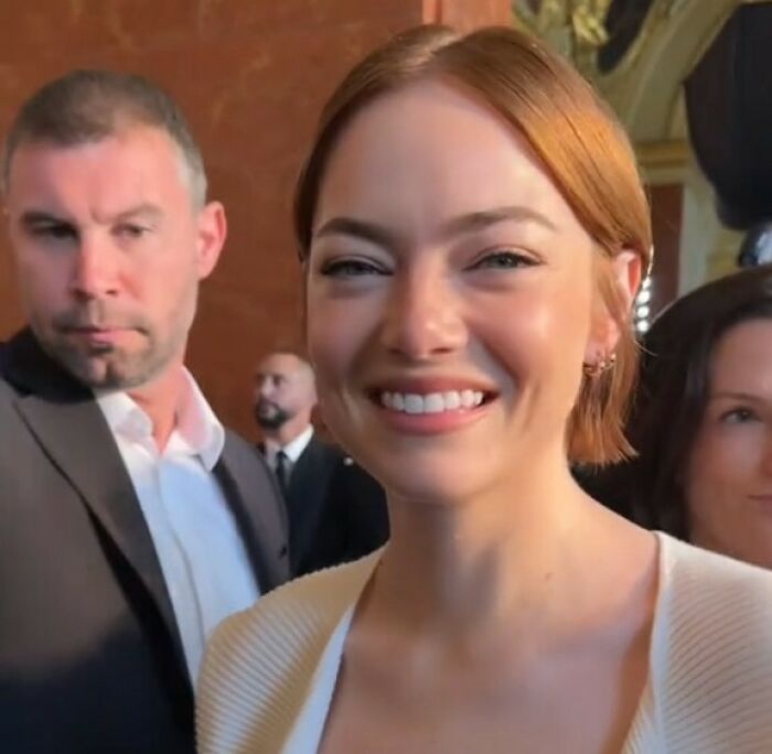 Emma Stone smiling at an event, sparking plastic surgery speculation in Louis Vuitton photos.
