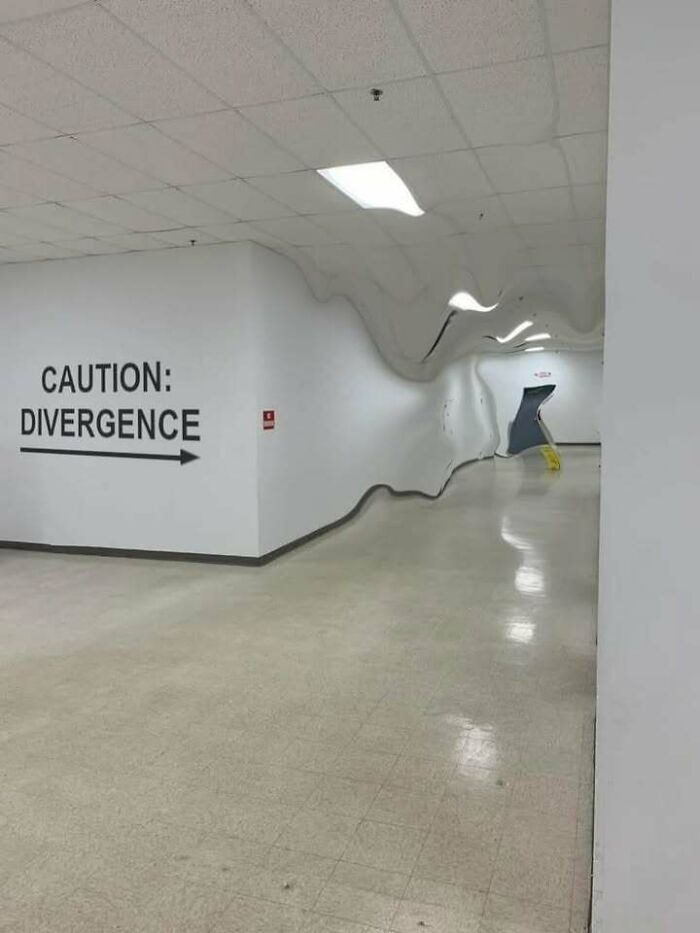 Distorted hallway with a caution divergence sign and warped walls creating a confusing and weird visual effect.